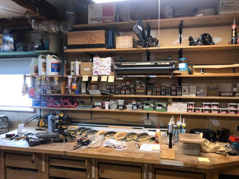 A shop or garage full of tools, glue, and boxes of nails on wooden shelves